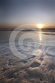 Long exposure, of the sea with orange sunset, Shells in the sand. Abstract view, background, card, greeting card, mourning card