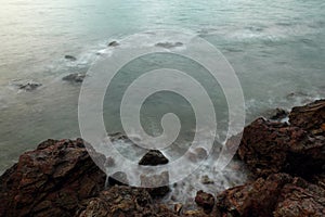 Long exposure of sea with smooth wave and rock