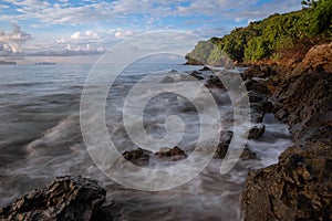 Long exposure of sea waves lash line impact rock on the beach at morning time at Koh yao yai,Thailand