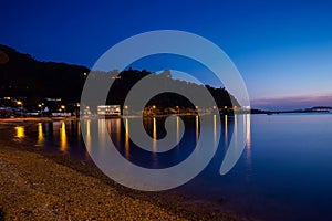 Long exposure shot of the beach at Lowry bay with a twlight sky and the smooth silky water