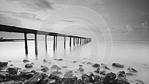 Long exposure shot of old broken jetty during pastel sunset.