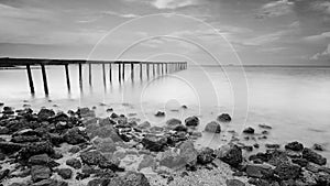 Long exposure shot of old broken jetty during pastel sunset.