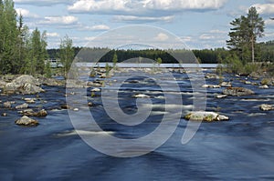 Long exposure shot of rapids in front of watergate in a Swedish river in Jaemtland