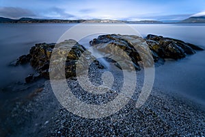 Long exposure shot of rocks in the sea in Moses Point, North Saanich, Vancouver Island, Canada