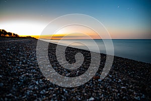 Sun going down over a pebbles beach in Denmark