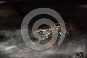 Long exposure shot of water running over stones at midnight