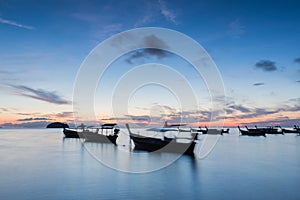 Long exposure silhouette long tail boats with sunrise sky in Koh Lipe Island