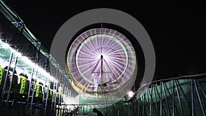 Long Exposure slow shutter speed Shot of a Spinning Ferris Wheel with beautiful lights in indian Fun Fair at night
