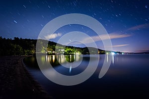 Long exposure of stars moving over Lake Winnipesaukee at night,