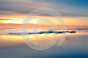 Long Exposure of Sunrise at the Paijanne lake. Beautiful scape with sunrise sky,fog, pine forest and water. Lake Paijanne, Finland