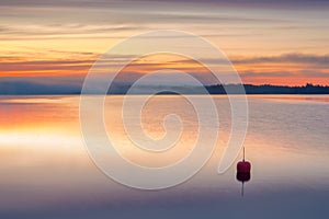 Long Exposure of Sunrise at the Paijanne lake. Morning on the lake. Beautiful scape with sunrise sky,fog, pine forest and water.