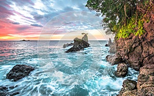 Ocean waves and coastal cliffs at sunset in Costa Rica photo