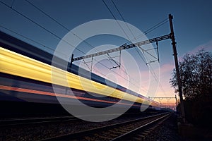 Long exposure of train on railroad track at sunrise