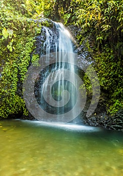 A long exposure view the Gendarme waterfall cascading into the plunge pool in the rain forest of Martinique