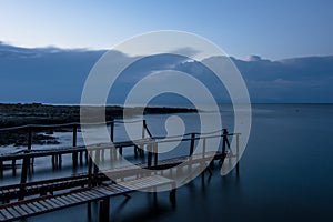 Long exposure: a wooden pier after sunset in a blu autumn sky photo