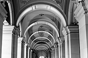 Long exterior portico of old Melbourne General Post Office Building with row of repeating illuminated arches