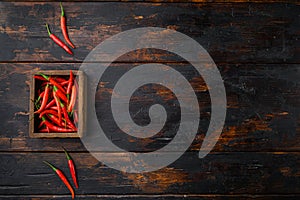 Long fed pepper, in wooden box, on old dark  wooden table , top view flat lay, with copy space for text