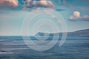 Long focus photography. Small fishing boat on the surface of Atlantic ocean.