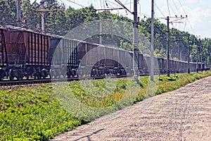 Long freight train with freight cars goes by rail