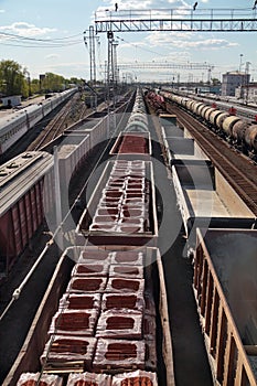 Long freight trains with bricks and sand at railways