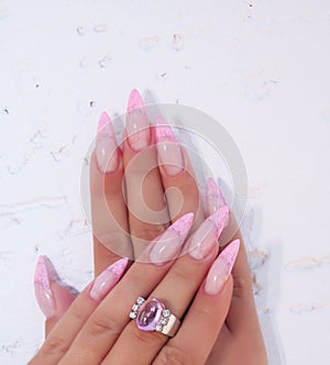Long French nails with white manicure on a woman`s hand