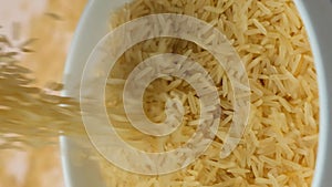 Long grain parboiled basmati rice pouring macro vertical slow motion