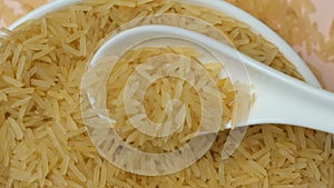 Long grain parboiled basmati rice pouring with spoon macro slow motion