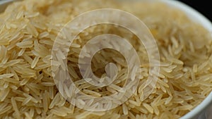 Long grain parboiled basmati rice rotating on black background