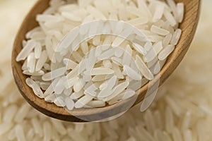 Long grain rice in a wooden spoon on a background plates . Healthy eating, diet