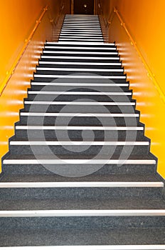 Long gray stairs with many steps and yellow wall