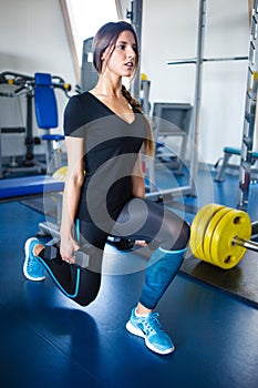 Long hail girl doing squats with a dumbbell