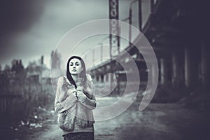 Long hair brunette girl outdoor with old industrial bridge behin