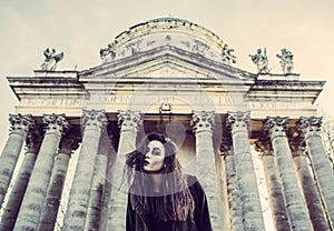 Long hair girl with scary makeup on the old church background