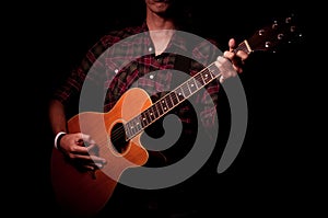 Long hair guy playing guitar acoustic