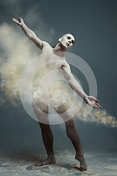 Long hair muscle man dancer in dust