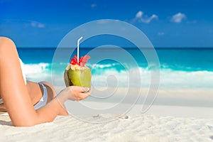 Long haired blonde woman with flower in hair in bikini on tropical beach