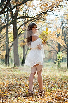 Long-haired girl with oak posy in autumn