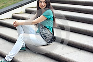 Long haired millenial woman in mint t-shirt and white jeans with