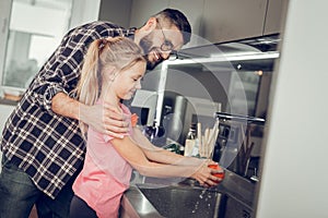 Long-haired pretty girl in a pink shirt spending a morning with her father