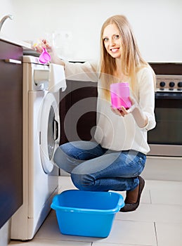 Long-haired woman doing laundry with detergent