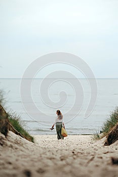 Long-haired woman with woven bag going to beach