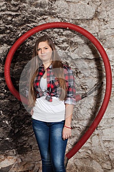 Long-haired young woman at old stone wall