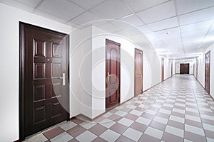 Long hallway with brown wooden doors