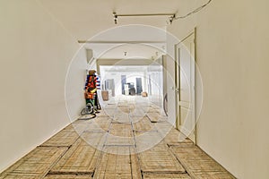 a long hallway with white walls and a wooden floor