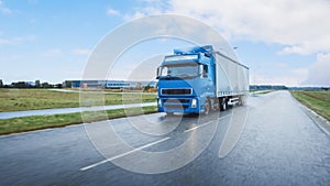 Long Haul Semi-Truck with Cargo Trailer Full of Goods Travels on the Highway Road. Daytime Driving