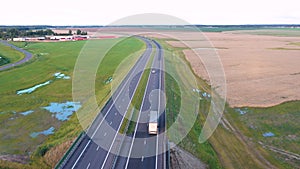 Long Haul Semi Truck Driving On Asphalt Highway Bridge In Rural Aerial View