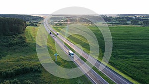 Long Haul Semi Truck Driving On Highway In Rural Hilly Region At Sunset