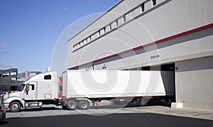 Long haul truck with trailer backed into warehouse loading dock