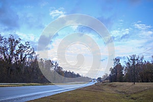 Long highway in the country on a cloudy rainy day with Fall colors in the south