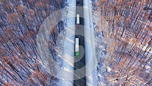 The long highway runs in a wooded area. Freight transport. The process of transportation of goods and cargoes along the